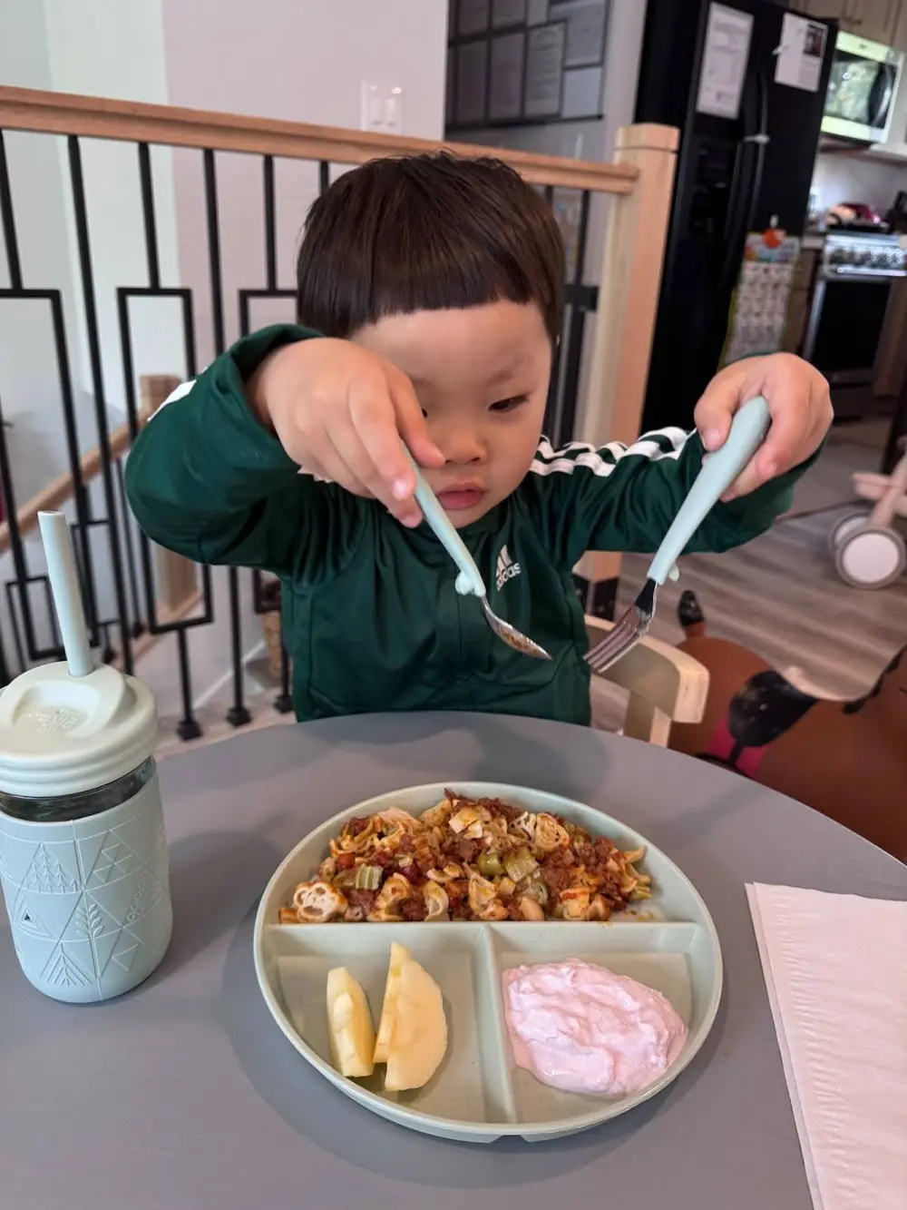 Child with sensory needs enjoying mealtime at Kido Heaven Child Care in Bothell, WA.
