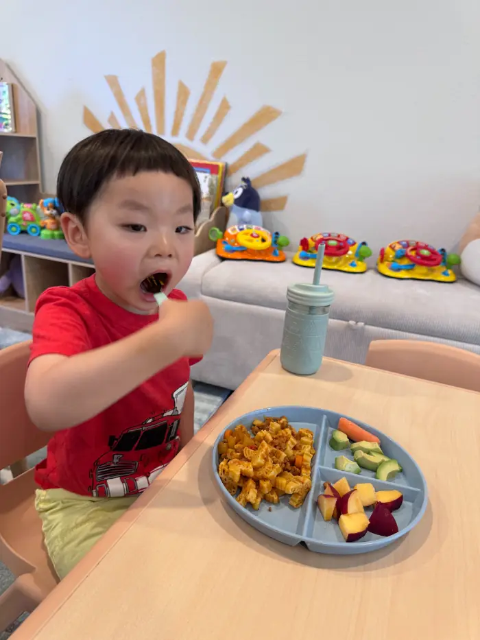 Toddler with healthy fruit snack in daycare.