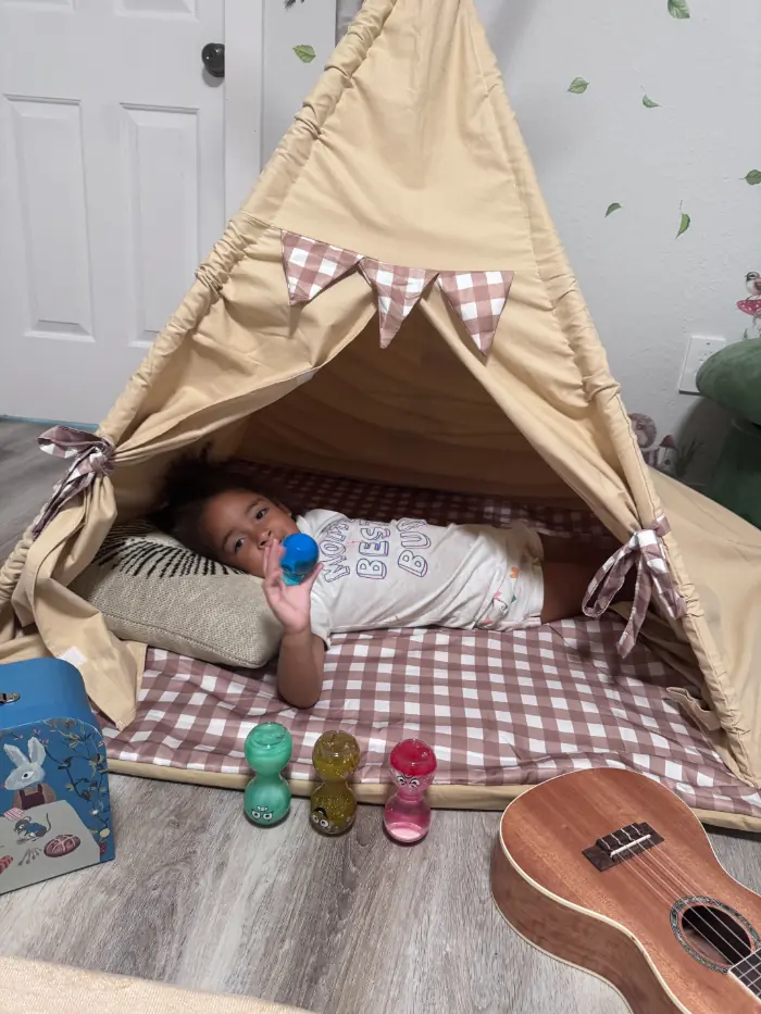 Toddler playing inside cozy indoor teepee – safe and stimulating play corner for daycare kids
