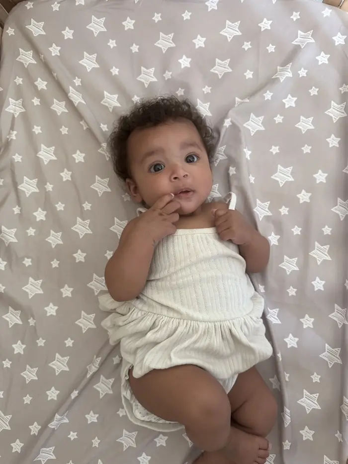 Infant sleeping on back in a clutter-free crib at daycare