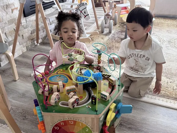 children playing together with toys, practicing positive behavior in a classroom