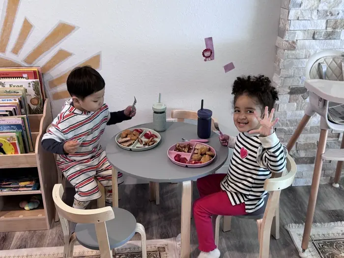 Preschool children eating together, practicing positive social behaviors in a classroom