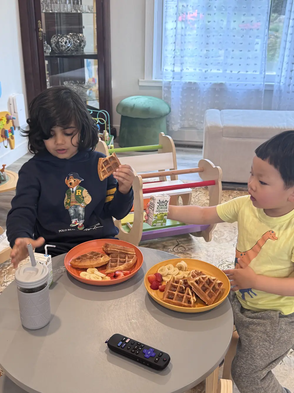 A group of toddlers eating at a low table in a distraction-free environment at KidoHeaven.