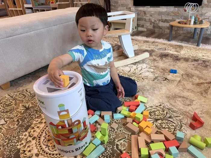 A toddler stacking blocks, representing early developmental milestones in fine motor skills.
