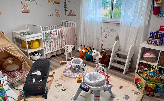 Infant room with cribs, a bouncer and floor toys